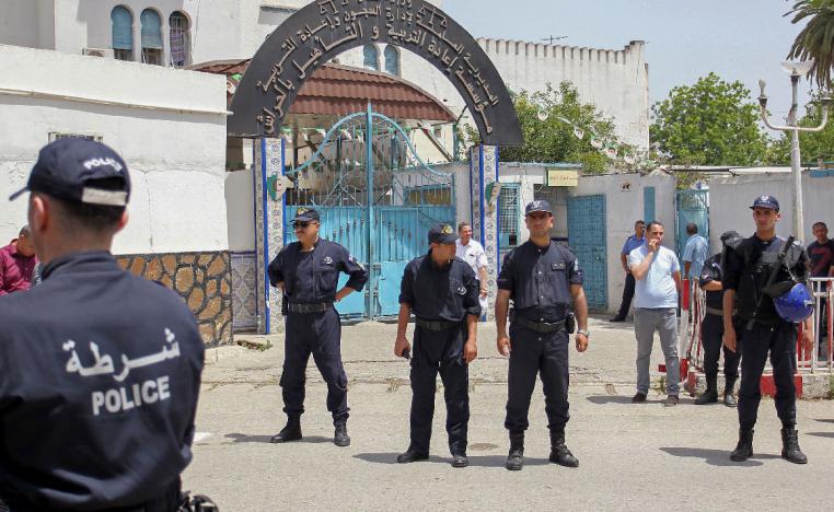 Algerian policemen stand guard outside the El Harrach prison in Algiers