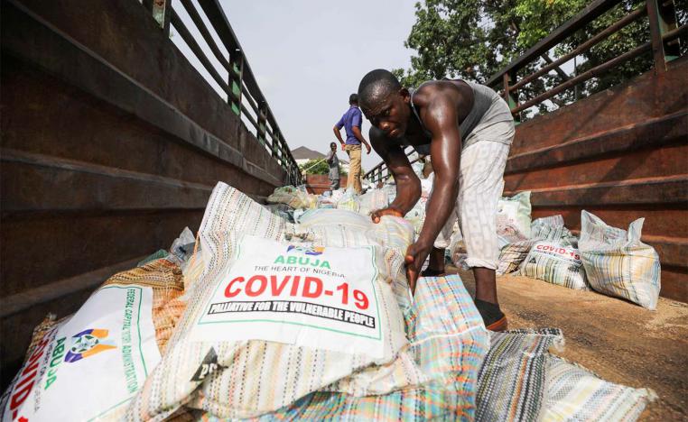 Men load sacks of rice among other food aid in a truck, to be distributed for those affected by procedures taken to curb the spread of coronavirus in Abuja