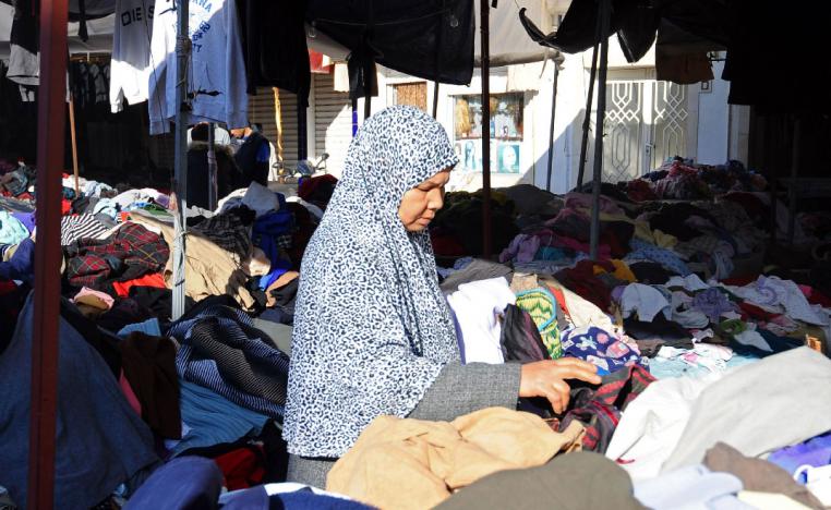 A Tunisian woman looks at clothes at a market in Tunis