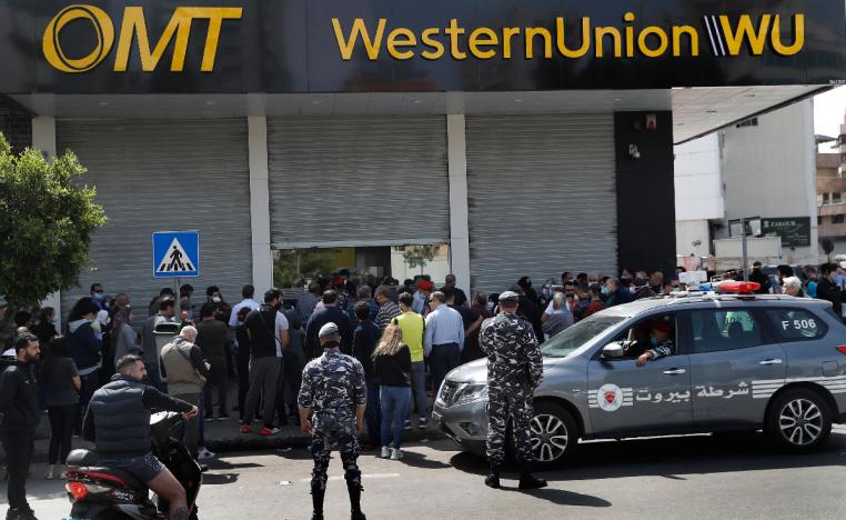 Lebanese citizens queue outside a Western Union shop to receive their money transfer in U.S. dollar currency
