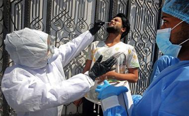 Iraqi public hospital specialised doctors test a resident for COVID-19 in the capital Baghdad's suburb of Sadr City