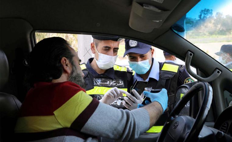 Jordanian policemen check the electronic pass of a driver in Amman