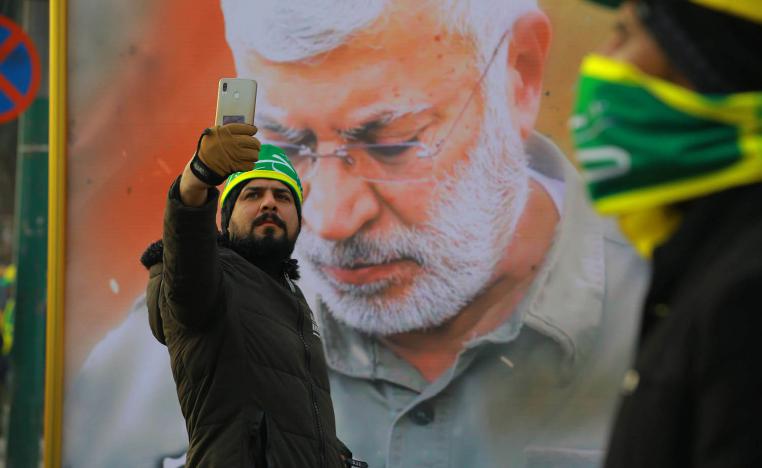 عراقي يأخذ سيلفي مع صورة أبو مهدي المهندس