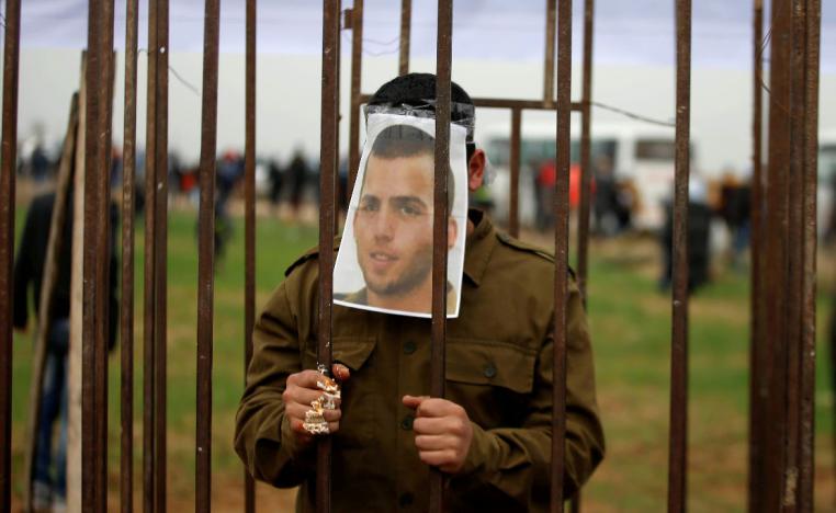 A Palestinian man playing the role of Israeli soldier Oron Shaul stands in a mock jail during a rally in solidarity with Palestinian prisoners