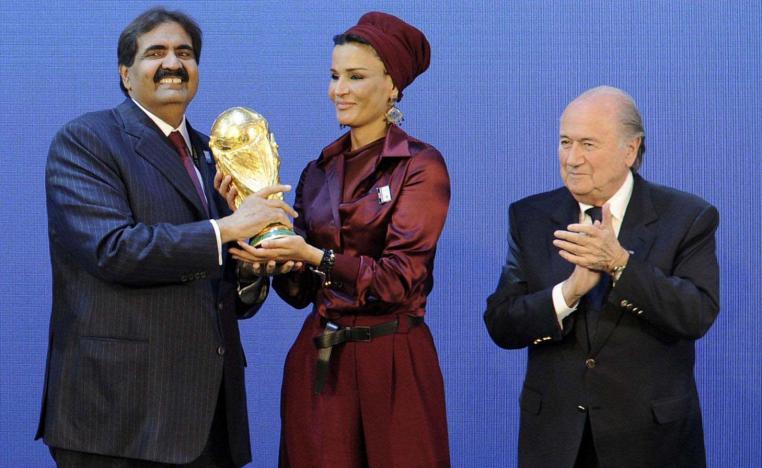Former Qatari emir holding the world cup with his wife