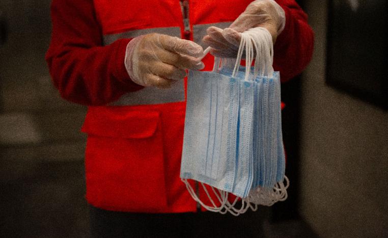 A Red Cross volunteer holds face masks for protection against the coronavirus