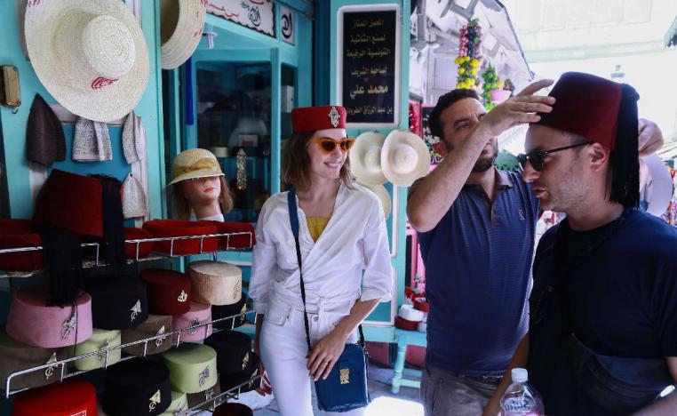 A tourist tries on a traditional fez at a bazaar in the Medina of Tunis