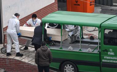 Officials put a coffin inside a funeral vehicle in an Istanbul morgue