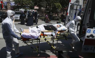 Medics wearing masks and suits against the coronavirus, take a patient out of an ambulance