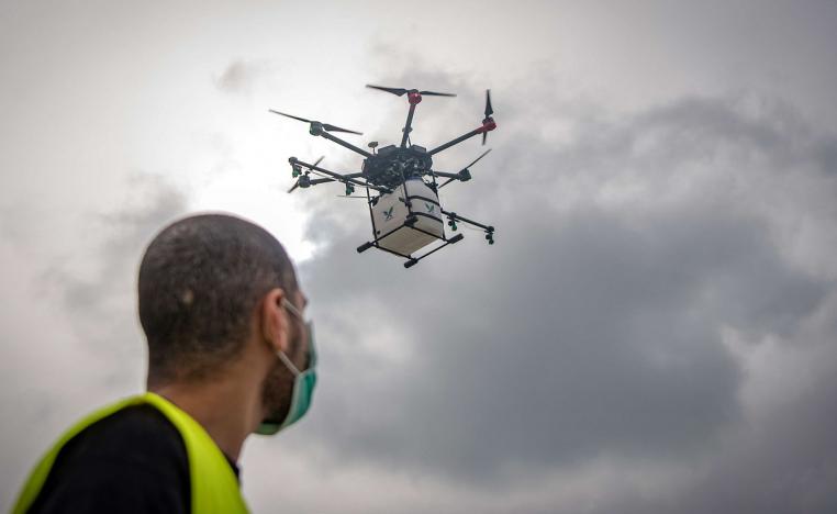 موظف في شركة مغربية ناشئة بتجربة طائرة بدون طيار مجهزة بسائل مطهر  في أحد الشوارع القريبة من العاصمة الرباط 