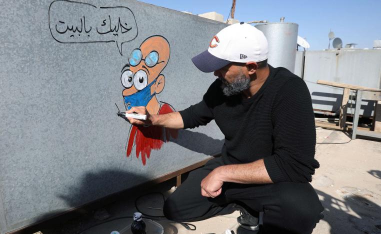 رسام الكاريكاتير الأردني أسامة حجاج يرسم على خزانات المياه 