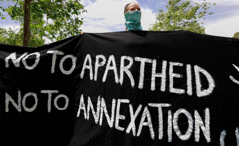 Israeli activist holds a banner during a protest against the US peace plan for the Middle East, in front of the US ambassador's residence in Jerusalem