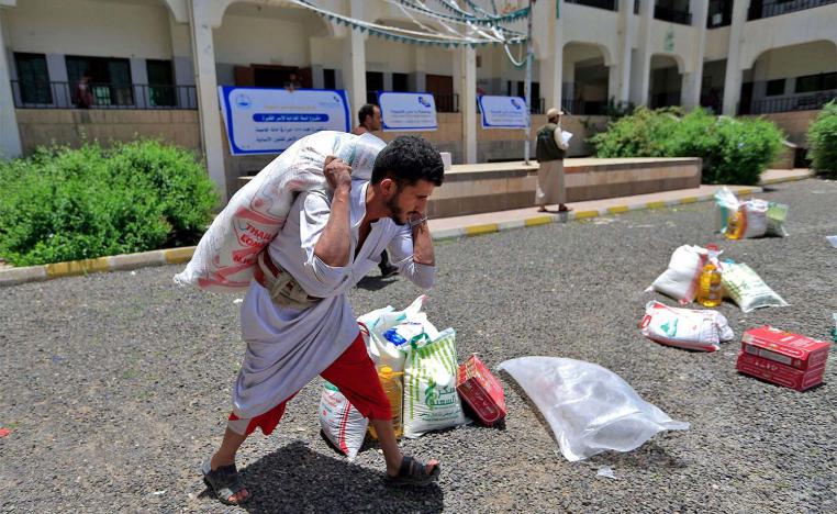 A Yemeni man carries a portion of food aid in Sanaa