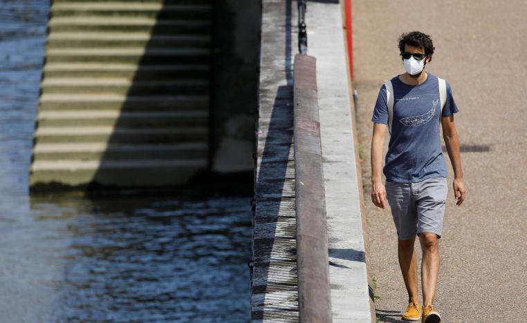 شاب بريطاني يرتدي كمامة واقية ويسير على الضفة الجنوبية في لندن