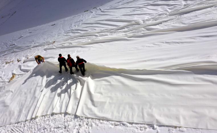 عمال يغطون بقماش أبيض نهر بريسينا الجليدي