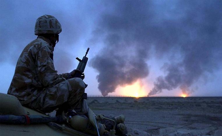 British soldier watching burning oil wells in southern Iraq on March 20, 2003 during US-led invasion of Iraq 