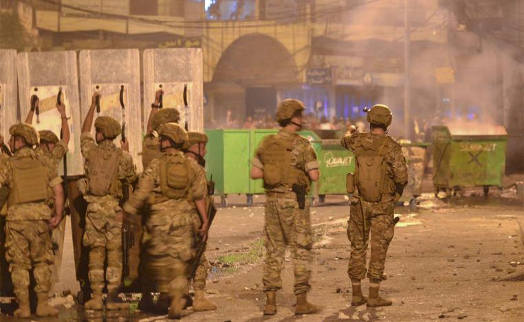 Lebanese soldiers with riot gear deploy during clashes with anti-government protesters in the northern port city of Tripoli
