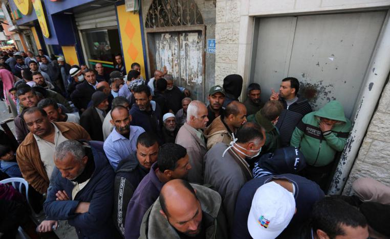 فلسطينيون ينتظرون صرف رواتبهم في مخيم خان يونس في غزة