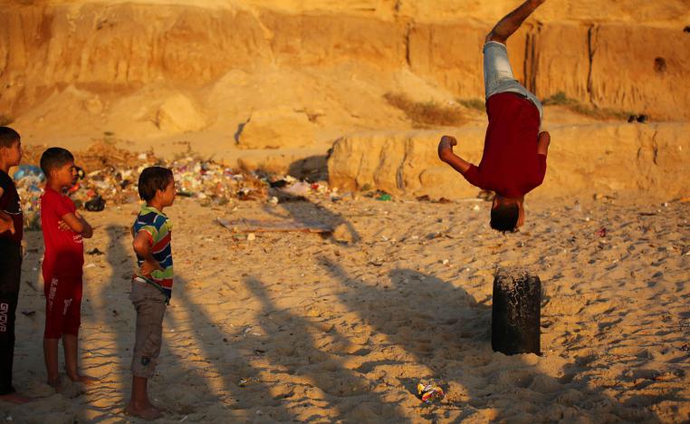 أطفال فلسطينيون يلعبون على ساحل البحر في دير البلح - غزة