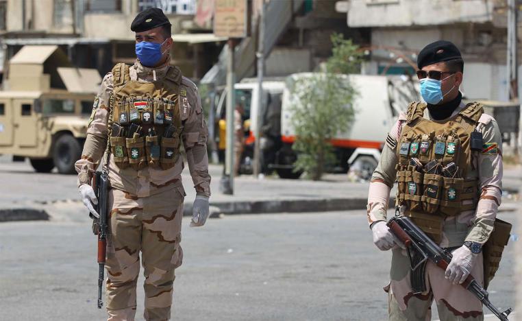 Iraqi security forces stand guard at a checkpoint in Baghdad