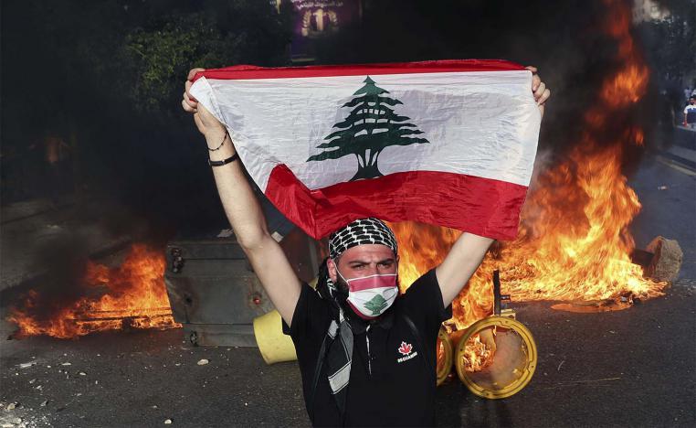 An anti-government protester holds up a Lebanese flag