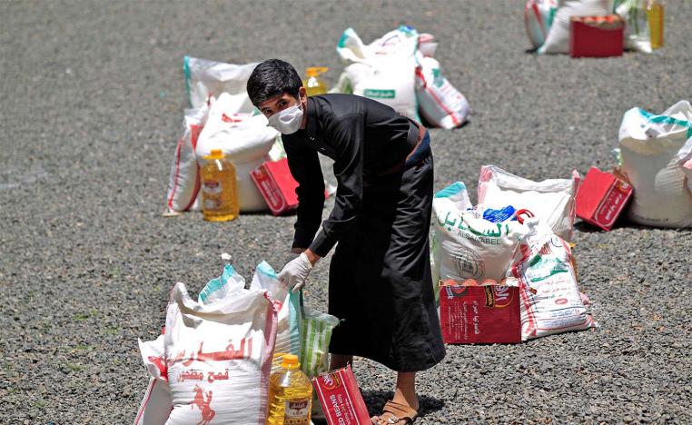 Yemeni youth carries a portion of food aid, distributed by Yadon Tabney development foundation in Sanaa
