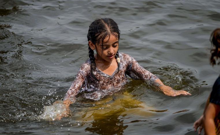 طفلة باكستانية تسبح خلال نهار حار