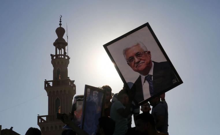 فلسطينيون يرفعون صورة الرئيس الفلسطيني محمود عباس
