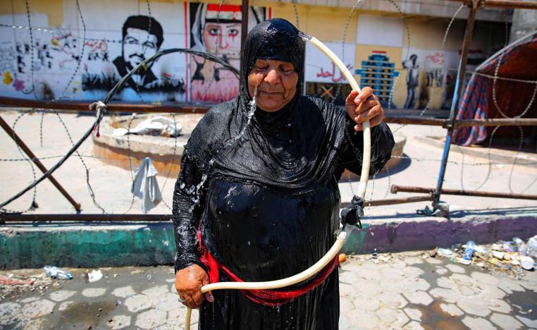عراقية ترش نفسها بالماء في ساحة التحرير ببغداد