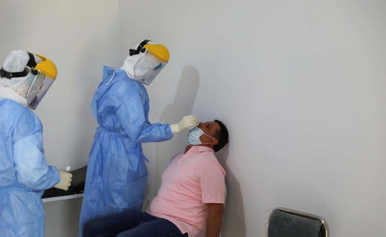 A member of a medical team takes a swab to test for the coronavirus disease