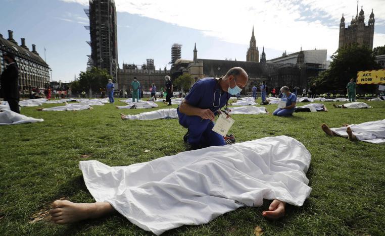 نشطاء من مجموعة احتجاج مناخي يقومون بتمثيل مسرحية لإلقاء الضوء على كوارث الاحترار