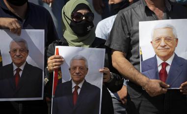 فلسطينيون يرفعون صورا للرئيس الفلسطيني محمود عباس