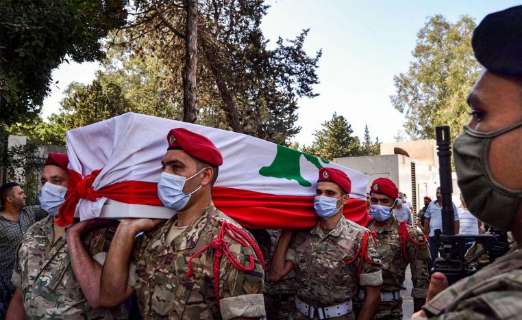 Lebanese army soldiers, clad in masks due to the COVID-19 coronavirus pandemic, carry the flag-draped coffin of their fallen comrade