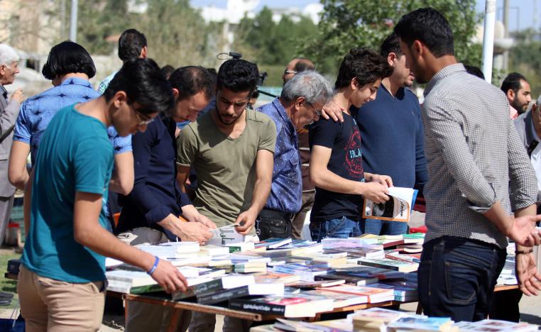 عراقيون يطالعون كتبا في شارع الفراهيدي بالبصرة