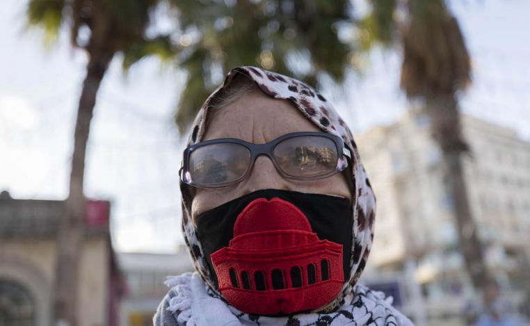 فلسطينية ترتدي كمامة عليها صورة القدس في مساندة للأسرى الفلسطينيين