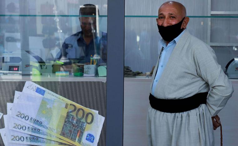 كردي أمام محل صرافة في السليمانية