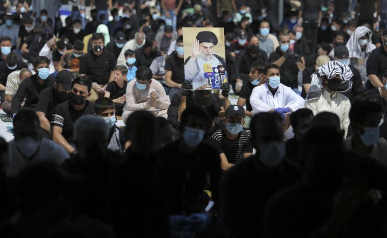 مؤيدون للتيار الصدري يرفعون صورة زعيمهم