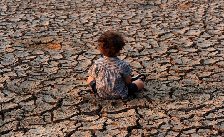 طفل في هندوراس يجلس في منطقة تضررت من الجفاف