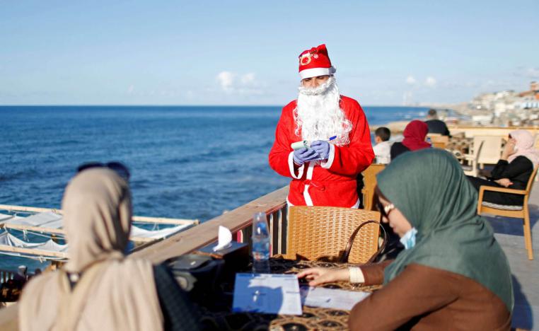فلسطيني يرتدي زي بابا نويل في مقهى في غزة