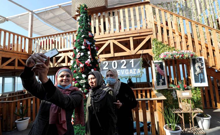 فلسطينيات يصورن انفسهن سيلفي مع شجرة عيد الميلاد في مقهى على ساحل غزة
