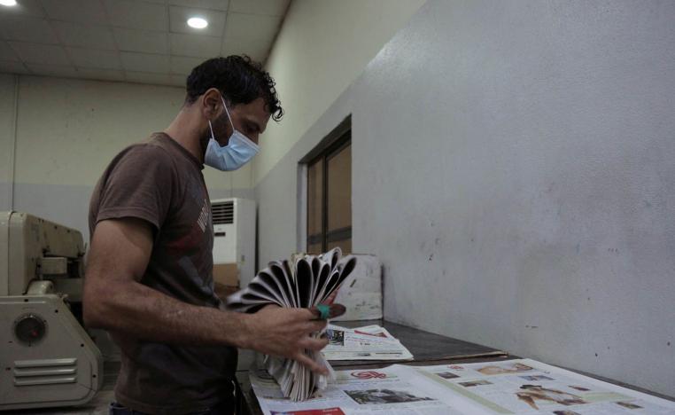موظف في صحيفة عراقية يقوم بتجميع الصحف