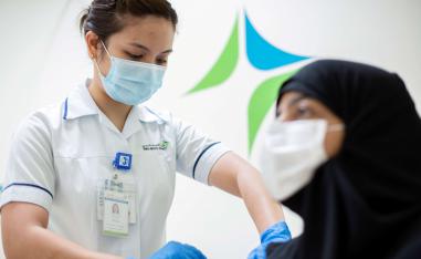 إماراتية تتلقى لقاح كورونا في مركز صحي بدبي