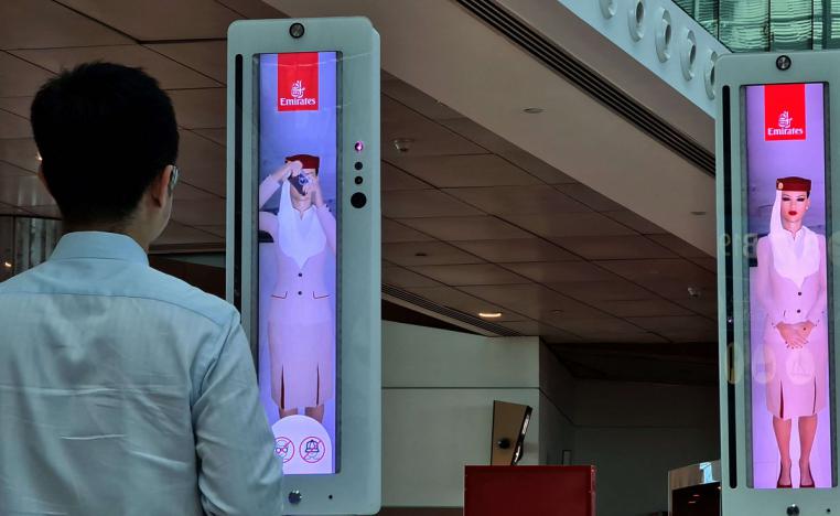 مسافر يعبر بوابة المسار السريع التي تستخدم تقنيات جديدة في مطار دبي الدولي