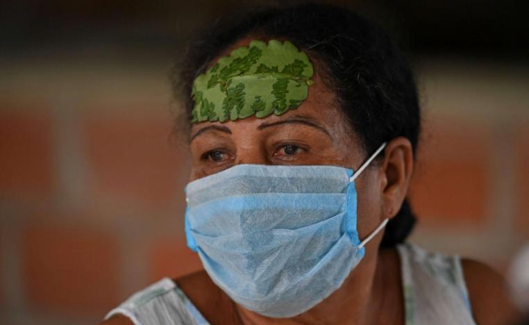امرأة كولومبية تضع على جبينها ورقة شجر لعلاج الصداع