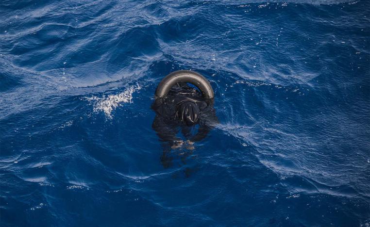 A dead migrant floats on the sea after his boat capsized off Libyan coast