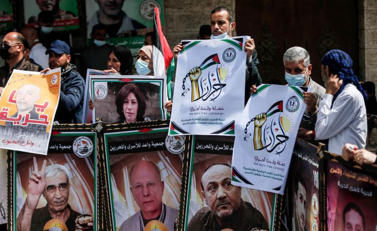 فلسطينيون يرفعون صورا لأسرى من زعماء الحركات الفلسطينية