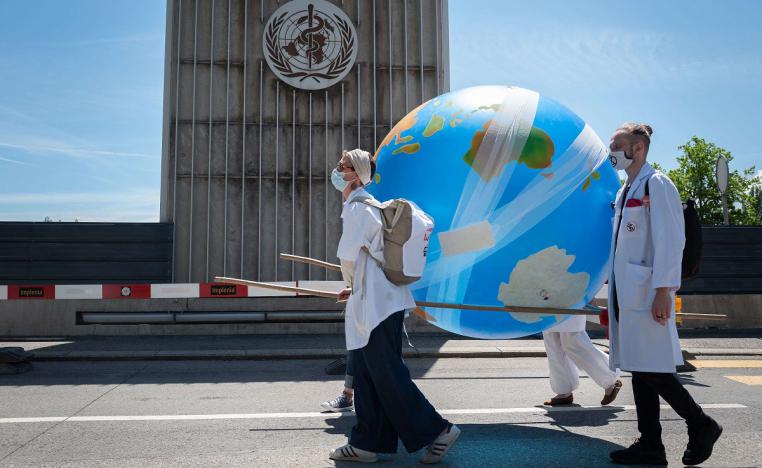 أطباء يحملون مجسما للكرة الأرضية مغطى بلصقات وضمادات الجروح