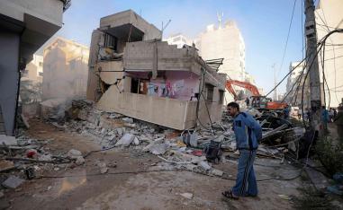 فلسطيني يقف بجانب منزل تم تدميره في غراة اسرائيلية في غزة