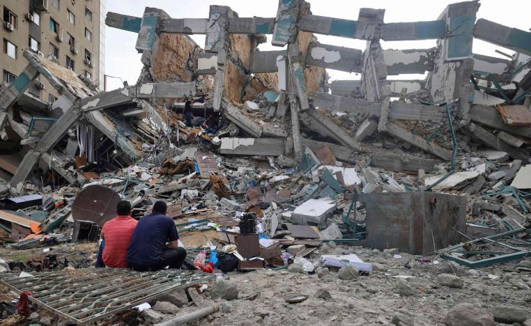 فلسطينيون أمام دمار خلفه القصف الاسرائيلي لغزة