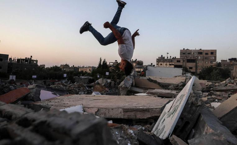 طفل فلسطيني يلعب على اطلال مبان مهدمة بالقصف في غزة